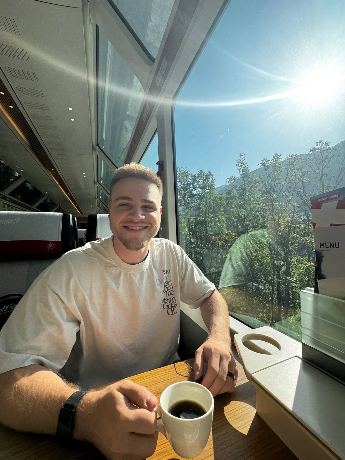 Alex enjoying coffee on a train during his August travels
